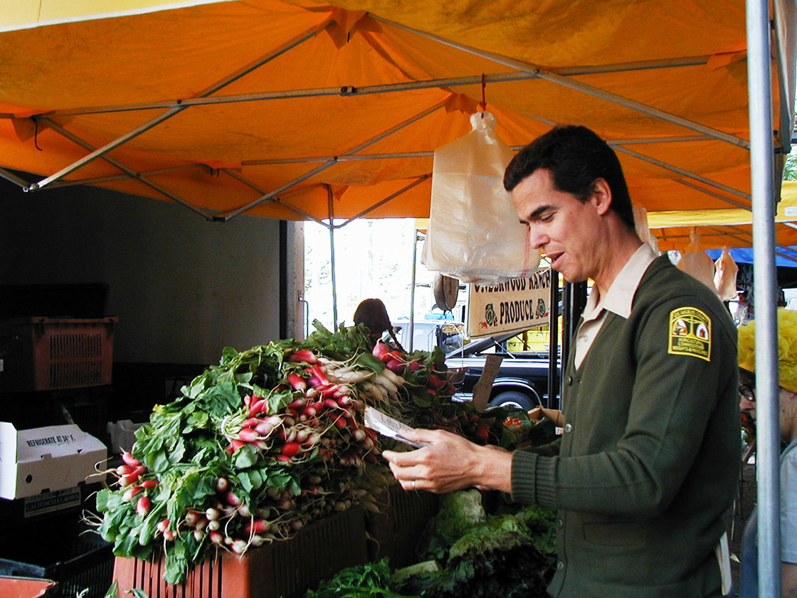Man inspecting produce at a farmers market